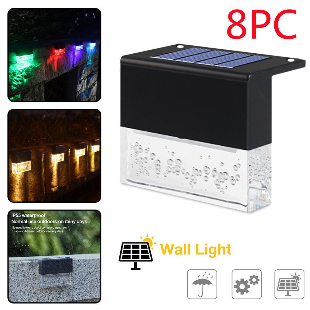 Waterproof New RGB RGB LED solar step lights illuminating a garden fence in multiple colors, waterproof and crystal-like for outdoor decoration.