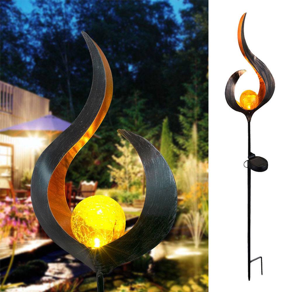 LED Solar Flame Light in decorative flame design illuminating garden at night.