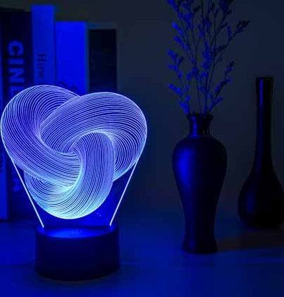 Twist Abstract LED 3D night light on a table with decorative vases, emitting a soft glow.