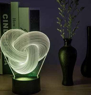 Twist Abstract LED 3D night light on a table with decorative vases, emitting a soft glow.