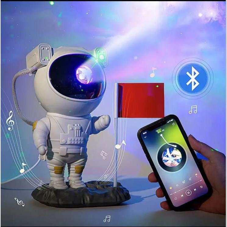 Astronaut-shaped galaxy starry sky projector lamp casting colorful nebula effects on walls.