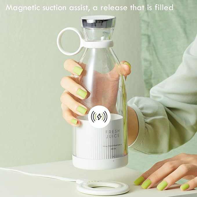 Portable Blendy Bottle blender with pink design next to a glass of juice, grapefruit, berries, and a palm leaf.