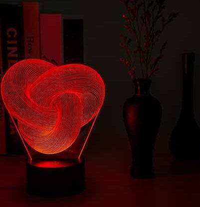 Twist Abstract LED 3D night light on a table with decorative vases, emitting a soft glow.
