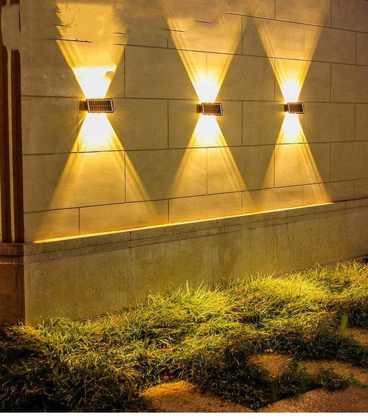 Solar outdoor wall lights illuminating a stone wall with warm light.