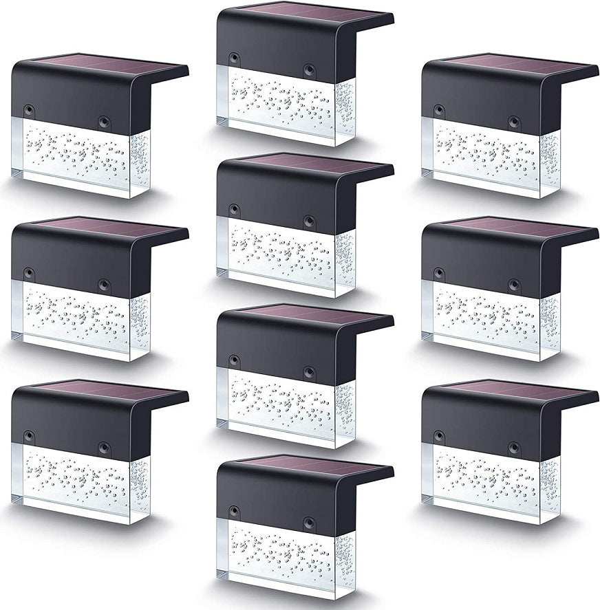 Waterproof New RGB RGB LED solar step lights illuminating a garden fence in multiple colors, waterproof and crystal-like for outdoor decoration.