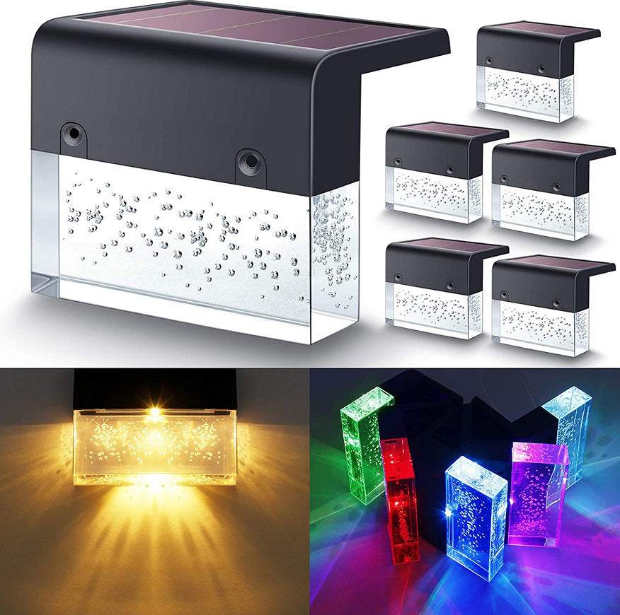 Waterproof New RGB RGB LED solar step lights illuminating a garden fence in multiple colors, waterproof and crystal-like for outdoor decoration.