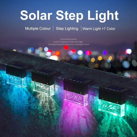 Waterproof New RGB RGB LED solar step lights illuminating a garden fence in multiple colors, waterproof and crystal-like for outdoor decoration.