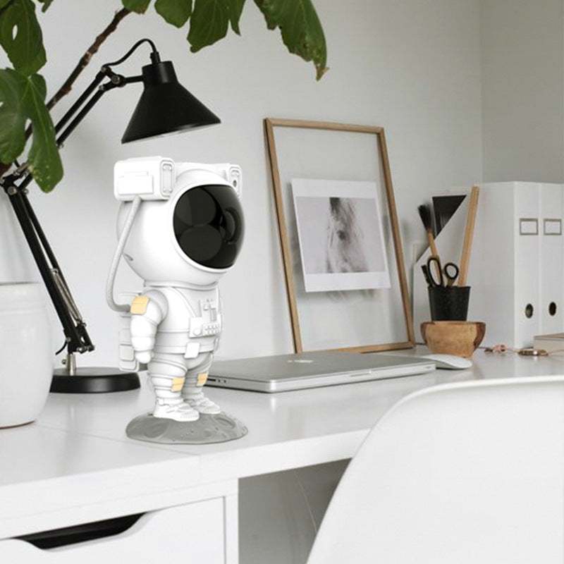 Astronaut-shaped galaxy starry sky projector lamp casting colorful nebula effects on walls.