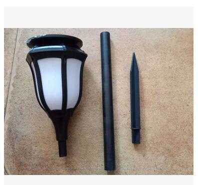 Outdoor pathway illuminated by LED waterproof solar torch lights with warm, flickering glow.