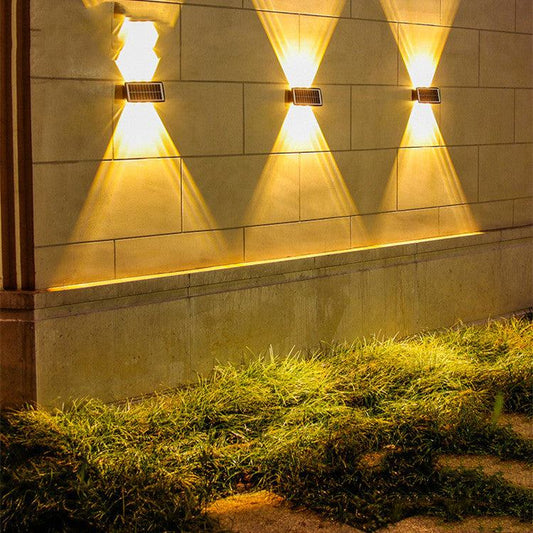 Solar outdoor wall lights illuminating a stone wall with warm light.