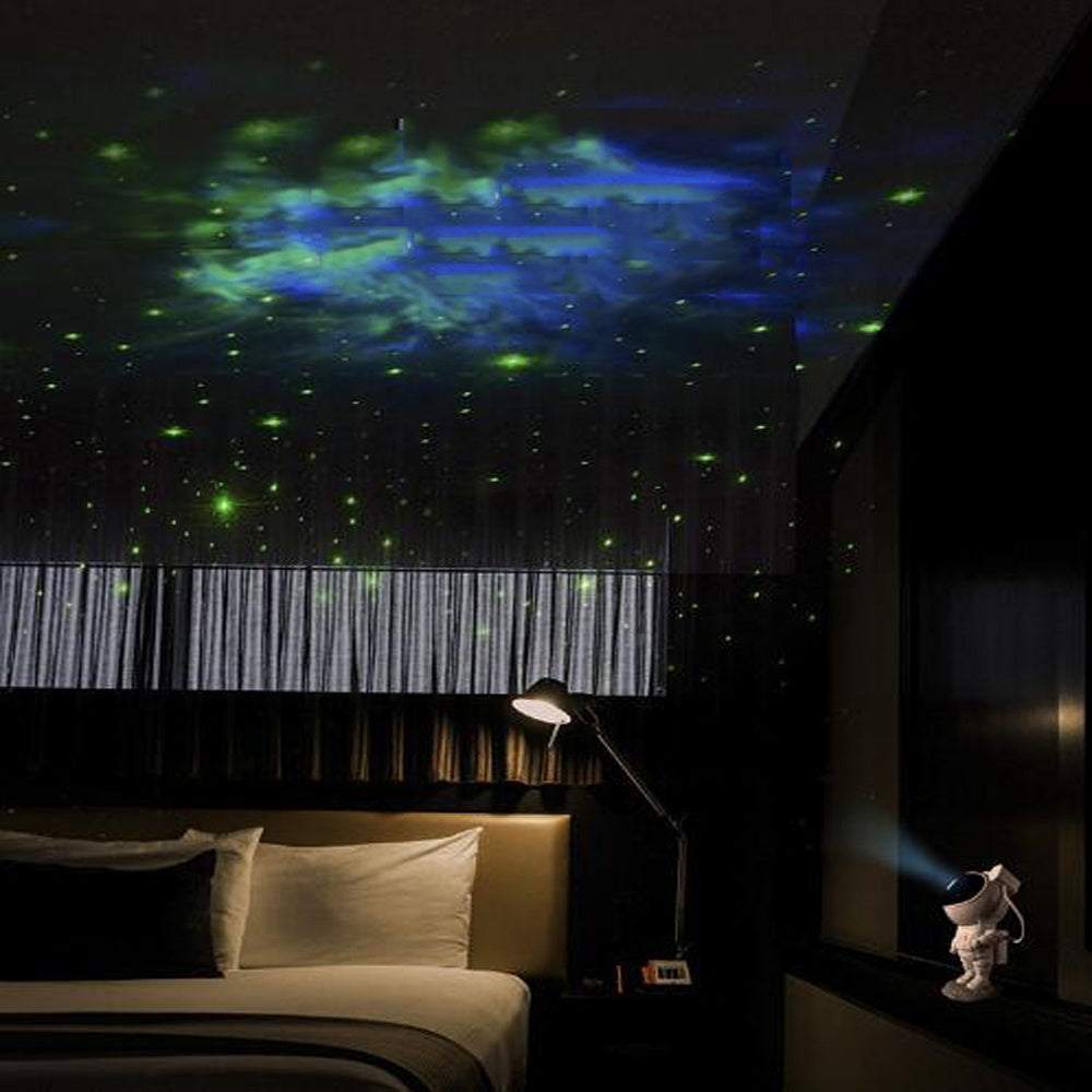 Astronaut-shaped galaxy starry sky projector lamp casting colorful nebula effects on walls.
