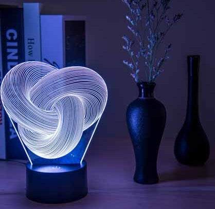 Twist Abstract LED 3D night light on a table with decorative vases, emitting a soft glow.