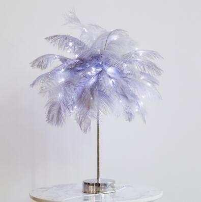 Nordic feather lamp with warm LED lights on a wooden base, perfect for bedroom decoration.