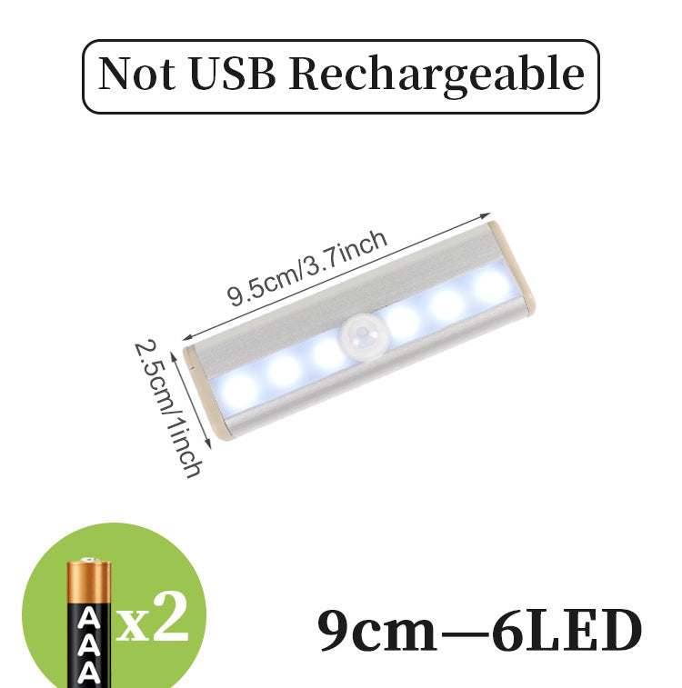 LED sensor light bar emitting warm light under a sofa.