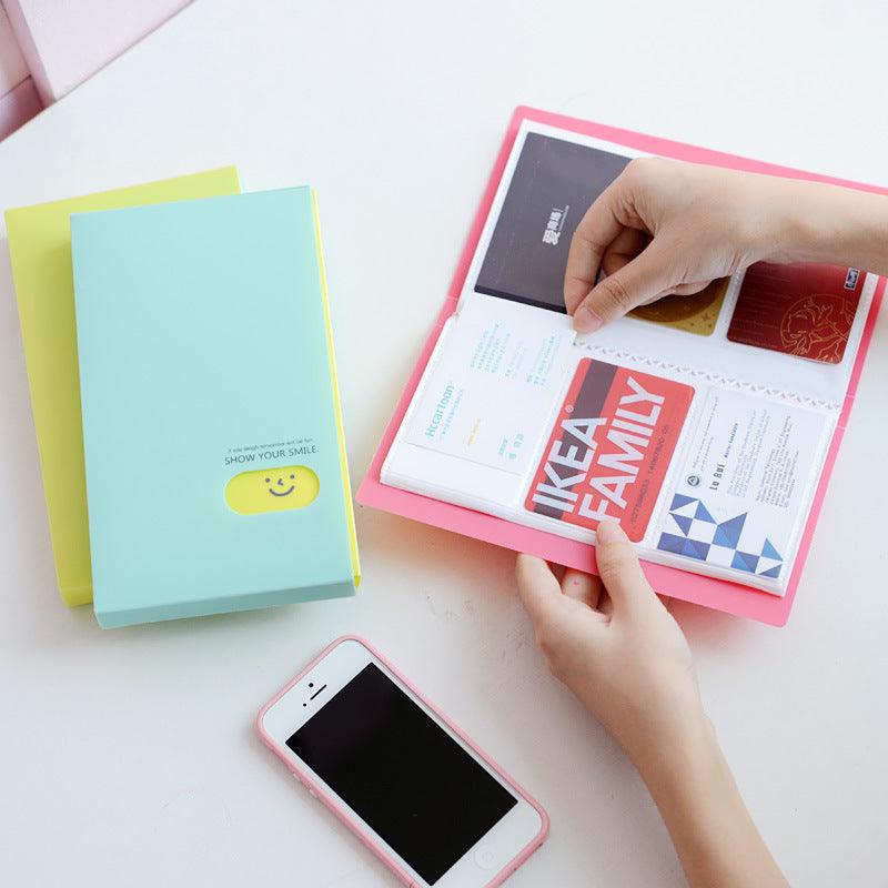 Plastic business card case in pink, open to show cards. Suitable for business gifts.