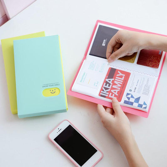 Plastic business card case in pink, open to show cards. Suitable for business gifts.