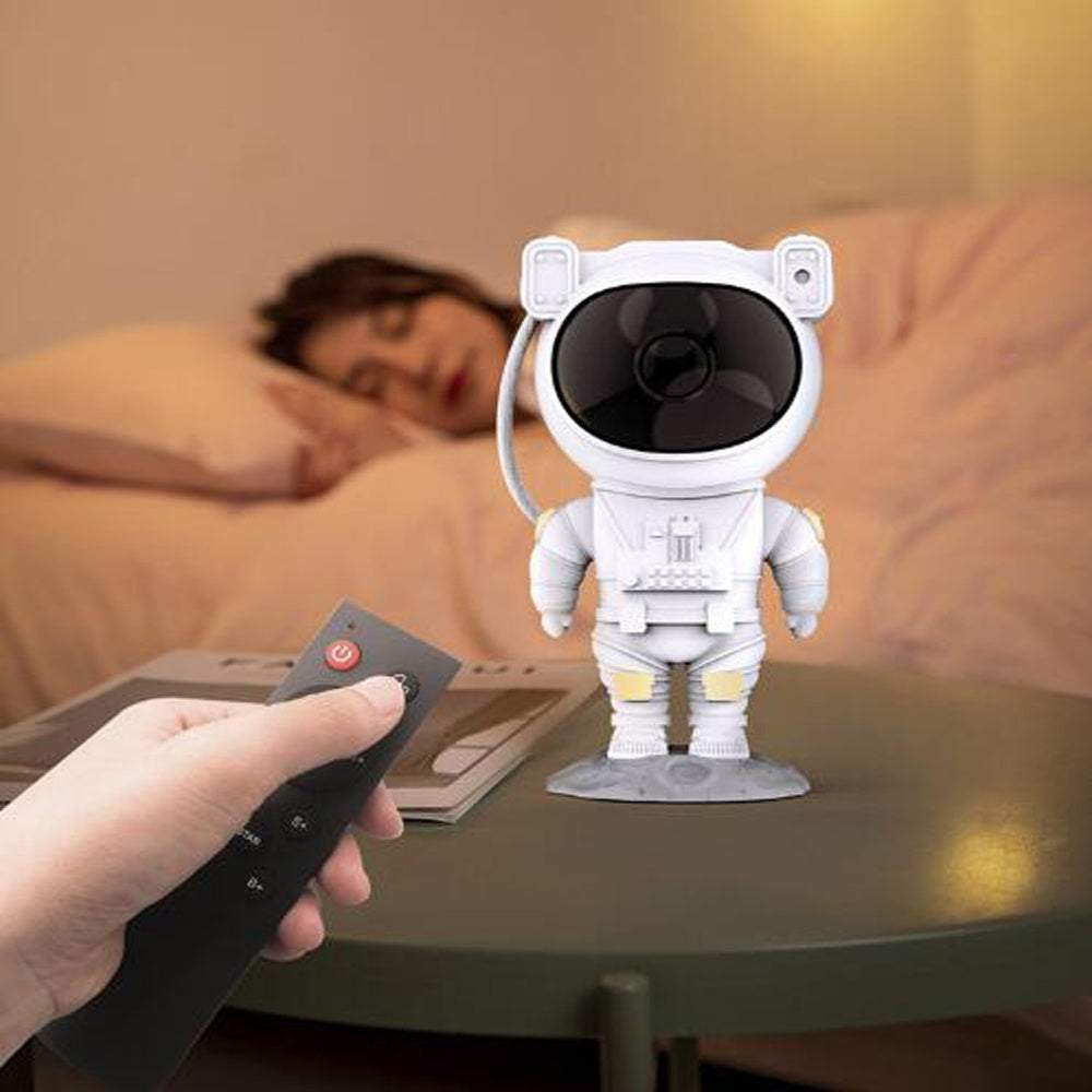 Astronaut-shaped galaxy starry sky projector lamp casting colorful nebula effects on walls.