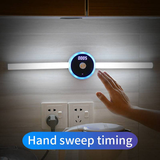 Smart cabinet light with clock and hand sweep timing feature, illuminating a wall.