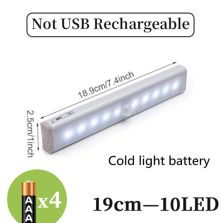 LED sensor light bar emitting warm light under a sofa.