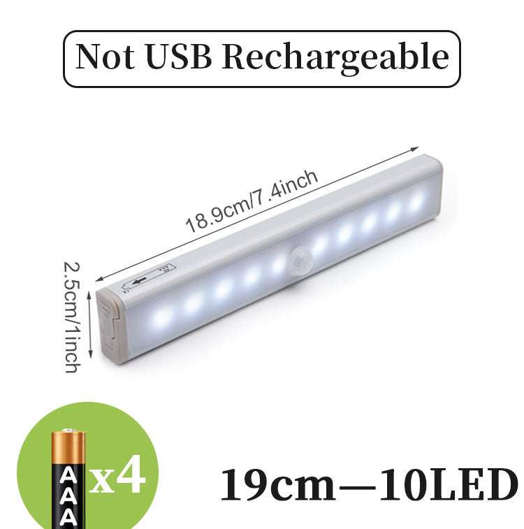 LED sensor light bar emitting warm light under a sofa.